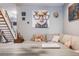 Stylish living room featuring a plush sectional sofa, unique artwork, and an open staircase design at 1150 Inca St # 43, Denver, CO 80204