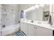Bright bathroom featuring a double vanity, shower-tub combo with stylish white tile, and modern fixtures at 15149 E Princeton Pl # D, Aurora, CO 80014