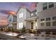 Charming modern townhome with beautiful landscaping and snow-dusted yard at sunset at 8055 Navajo River Loop # B, Littleton, CO 80125