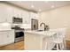 Close-up of kitchen island with stainless steel appliances and white cabinets at 8055 Navajo River Loop # B, Littleton, CO 80125
