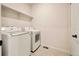 Functional laundry room with a washer, dryer, and shelving for storage and convenience at 8055 Navajo River Loop # B, Littleton, CO 80125
