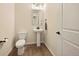 Clean powder room featuring a pedestal sink, toilet, and neutral wall color at 8055 Navajo River Loop # B, Littleton, CO 80125