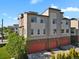 Modern townhouse with multi-toned facade, orange garages, and solar panels at 8187 Martin Luther King Blvd, Denver, CO 80238