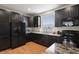 Modern kitchen features dark cabinetry, stainless steel appliances, and granite countertops with an eat-in bar at 8187 Martin Luther King Blvd, Denver, CO 80238