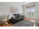 Cozy living room featuring a leather sofa, area rug, and ample natural light at 8187 Martin Luther King Blvd, Denver, CO 80238