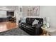 Living room features a dark leather sofa, hardwood floors and modern decor at 8187 Martin Luther King Blvd, Denver, CO 80238