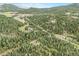 Beautiful aerial view of the property surrounded by lush greenery and mountains in the background at 10142 S Turkey Creek Rd, Morrison, CO 80465