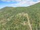 Aerial view of a home site with a long driveway winding through acres of wooded land at 10142 S Turkey Creek Rd, Morrison, CO 80465