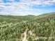 Aerial view of wooded acreage with a home nestled among the trees, offering seclusion and panoramic views at 10142 S Turkey Creek Rd, Morrison, CO 80465