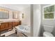 Bright bathroom featuring a soaking tub, wood vanity, and checkered tile floor detail at 10142 S Turkey Creek Rd, Morrison, CO 80465