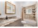 Bathroom featuring a granite vanity, decorative mirror, and a shower-tub with tile accents at 10142 S Turkey Creek Rd, Morrison, CO 80465
