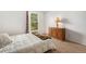 Bright bedroom with a plush bed, window views, and wooden dresser with lamp at 10142 S Turkey Creek Rd, Morrison, CO 80465
