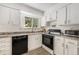 Bright kitchen with white cabinets, granite countertops and modern black appliances at 10142 S Turkey Creek Rd, Morrison, CO 80465