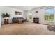Spacious living room with plush carpeting, a cozy sofa, and large windows offering scenic views at 10142 S Turkey Creek Rd, Morrison, CO 80465
