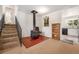 Cozy living room with a rustic wood stove and view into the kitchen area at 10142 S Turkey Creek Rd, Morrison, CO 80465