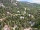 A beautiful aerial view showcasing homes nestled within a lush, green forest landscape at 30382 Kings Valley East, Conifer, CO 80433