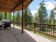 A partially covered back porch features forest views, with seating and a hot tub available for relaxing at 30382 Kings Valley East, Conifer, CO 80433