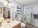 The bathroom features a wood vanity, framed mirror, toilet, and a glass-enclosed standing shower with updated fixtures at 30382 Kings Valley East, Conifer, CO 80433