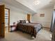The bedroom offers neutral carpeting, a queen-sized bed with patterned bedding, and access to an attached bathroom at 30382 Kings Valley East, Conifer, CO 80433