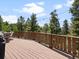 Spacious deck featuring wooden flooring, a grill, and a table with chairs at 30382 Kings Valley East, Conifer, CO 80433