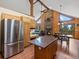 Open concept kitchen and living area with stainless appliances and stone fireplace at 30382 Kings Valley East, Conifer, CO 80433