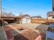Charming backyard featuring a fire pit, detached garage, and covered patio perfect for outdoor entertaining at 1561 Newton St, Denver, CO 80204