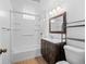 Bright bathroom featuring a shower-tub combo, a wooden vanity, and neutral paint at 1561 Newton St, Denver, CO 80204