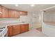 A simple kitchen with wood cabinets, white appliances, and an open view to another room at 1561 Newton St, Denver, CO 80204