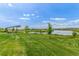 Scenic community with lush green lawn, a pond, and a covered picnic area at 12513 Shore Point St, Firestone, CO 80504