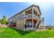 Spacious backyard with a patio, upper porch, and stairs leading down to the lawn at 12513 Shore Point St, Firestone, CO 80504
