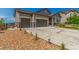Exterior front view showcasing landscaping, stone accents, three car garage, and a concrete driveway at 12513 Shore Point St, Firestone, CO 80504