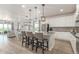 Well-lit kitchen showcasing a center island, white cabinets, and open to dining and living area at 12513 Shore Point St, Firestone, CO 80504