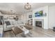 Cozy living room showcasing a fireplace with white mantel, wood floors, and sofas at 12513 Shore Point St, Firestone, CO 80504