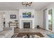 Well-lit living room featuring a fireplace with white mantel, wood floors, and sliding glass doors at 12513 Shore Point St, Firestone, CO 80504