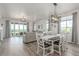 Open concept living space with dining area, kitchen, living room, and sliding doors to outdoor balcony at 12513 Shore Point St, Firestone, CO 80504