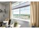 A view of the serene lake framed by a large window with neutral curtains at 12513 Shore Point St, Firestone, CO 80504