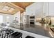 Stylish kitchen offers bar seating, stainless steel appliances, and a striking wooden ceiling feature at 2650 W Asbury Ave, Denver, CO 80219
