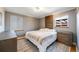 Cozy bedroom featuring hardwood floors, a unique wood accent wall, and plenty of natural light at 5611 E 13Th Ave, Denver, CO 80220