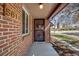 Inviting front entrance featuring a brick exterior and secure screen door, creating a warm and welcoming approach to the home at 5611 E 13Th Ave, Denver, CO 80220