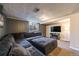 Basement living room with gray walls and carpet features a large sectional and entertainment center at 5611 E 13Th Ave, Denver, CO 80220
