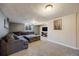 Basement living room with gray walls and carpet features a large sectional and entertainment center at 5611 E 13Th Ave, Denver, CO 80220
