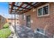 View of the covered back patio featuring brickwork, tile flooring and decorative outdoor lighting at 5611 E 13Th Ave, Denver, CO 80220