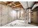 Unfinished basement featuring concrete walls, exposed ceiling, and mechanical equipment at 8040 Holland Ct # C, Arvada, CO 80005