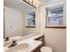 Bright bathroom with a large mirror, white countertops, and natural light from two windows at 8040 Holland Ct # C, Arvada, CO 80005