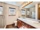Bathroom featuring a large mirror, double sink vanity, wood cabinets, and glass enclosed shower at 8040 Holland Ct # C, Arvada, CO 80005