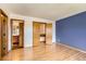 Bedroom featuring hardwood floors, a closet, and a blue accent wall at 8040 Holland Ct # C, Arvada, CO 80005
