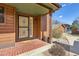 Close-up of a charming entryway with brick accents, a secure screen door, and inviting decor at 8040 Holland Ct # C, Arvada, CO 80005