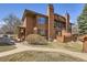 Charming two-story home boasts a warm wood exterior, complemented by mature landscaping and a welcoming walkway at 8040 Holland Ct # C, Arvada, CO 80005