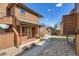 Two-story condo with wood exterior, a covered entry, and a walkway leading to a parking area with storage garages at 8040 Holland Ct # C, Arvada, CO 80005