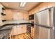 Modern kitchen boasts stainless steel appliances, granite countertops, and ample light wood cabinet space for storage at 8040 Holland Ct # C, Arvada, CO 80005